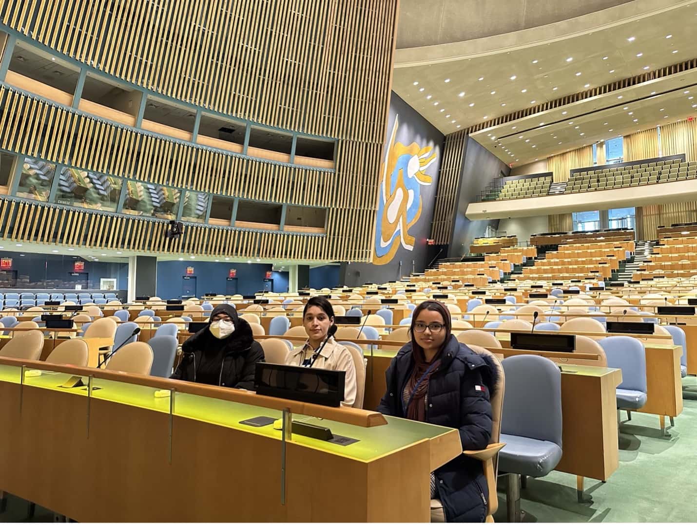 Three participating interns sitting in the General Assembly hall.