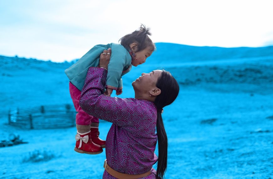 Beauitful image of smiling woman lifitng a child. 